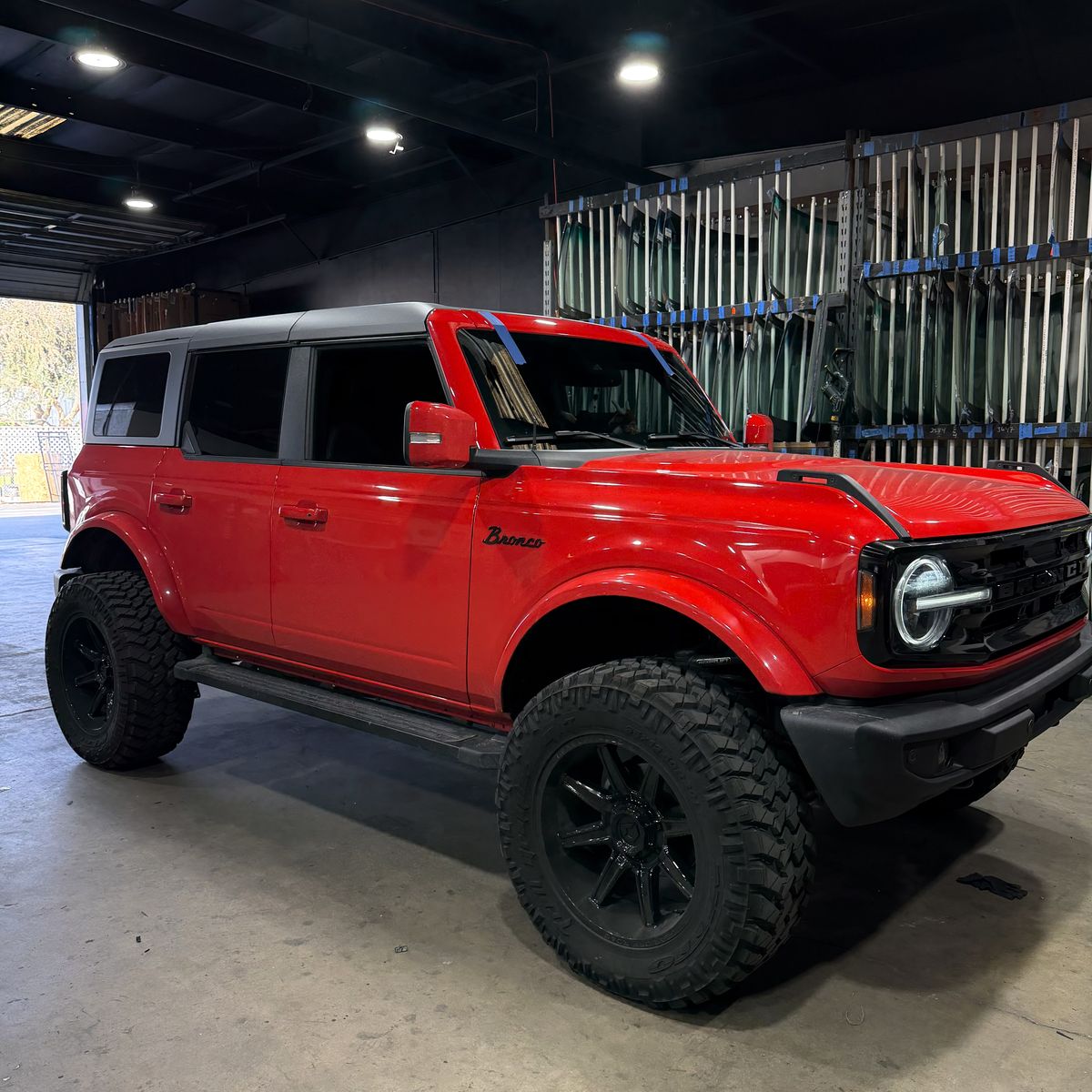 Ford Bronco with the auto glass inventory rack in the background
