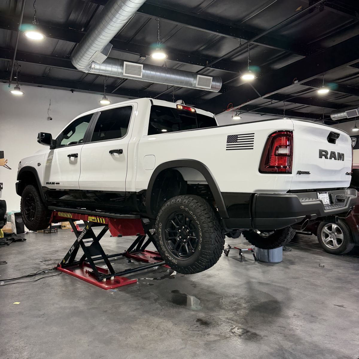 A truck raised on a lift in the Best Auto Care shop