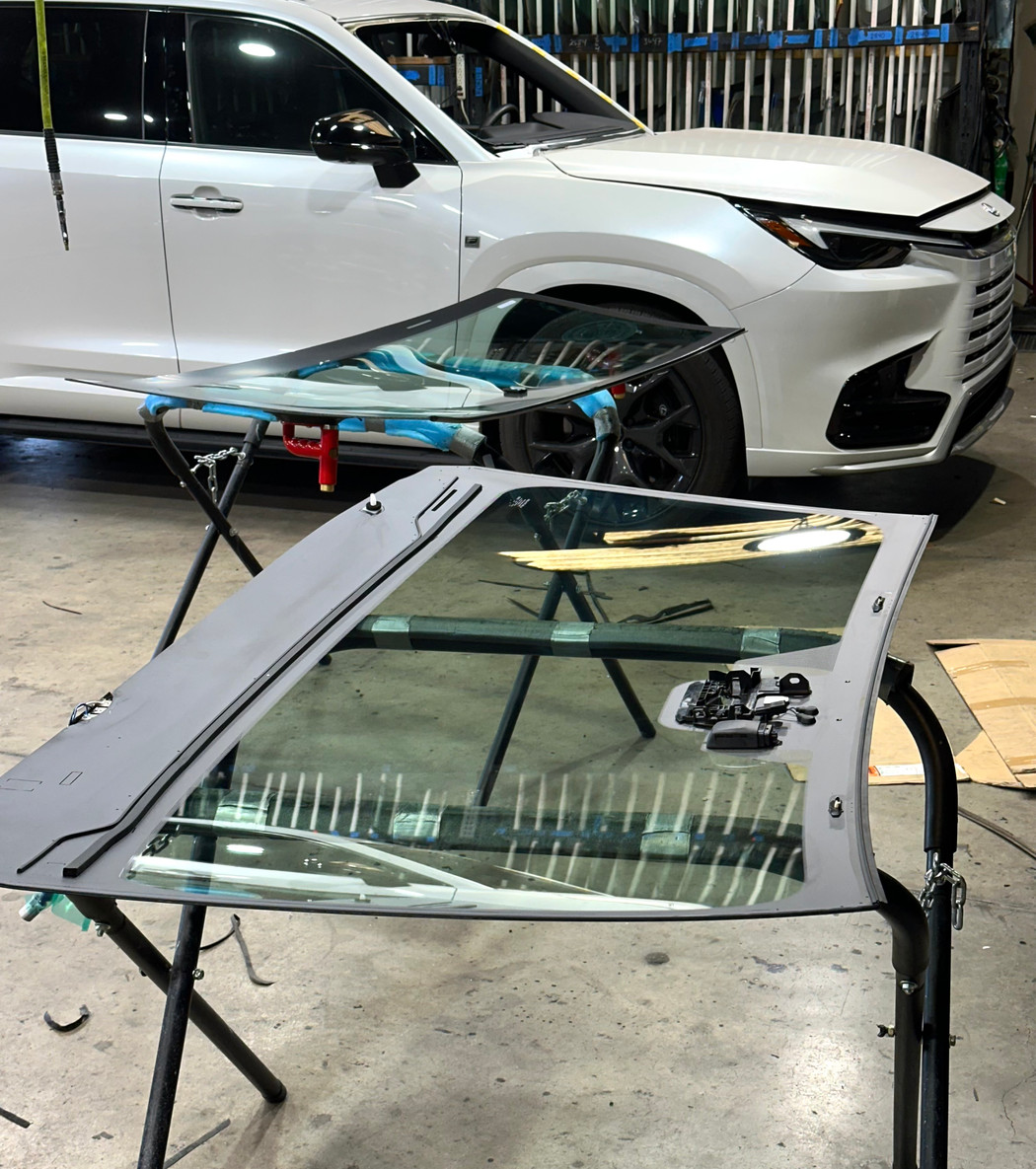 Replacement auto glass prepared on stands in the shop