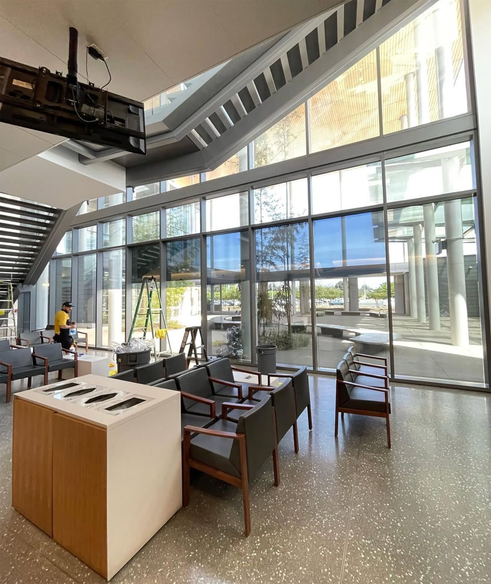 Technician installing window film in a large commercial glass atrium